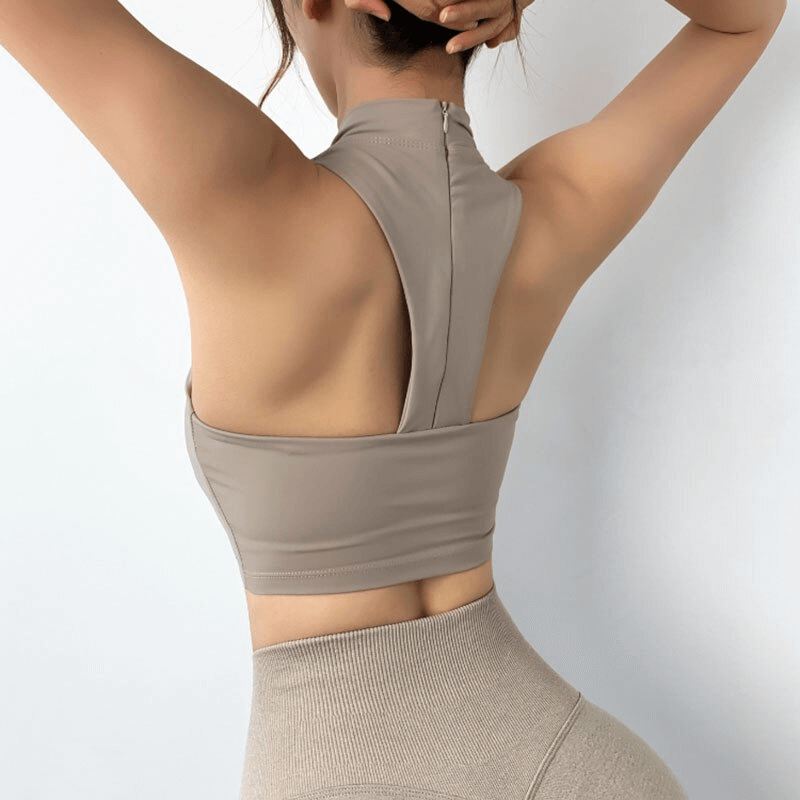Woman wearing a stylish elastic sports bra with an open back design, showcasing adjustable straps and comfort for fitness activities.